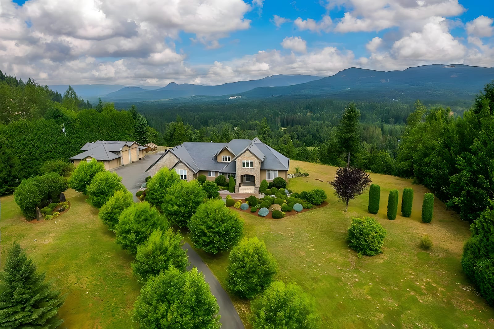 Aerial view of an acreage estate in Thornhill, Maple Ridge, with mountains beyond