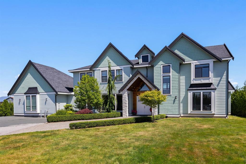 A large 2-storey detached home with a wide front lawn in Murrayville, Langley