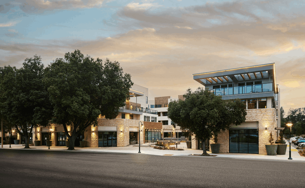 Modern mixed-use development with preserved oak trees at dusk — Thousand Oaks area