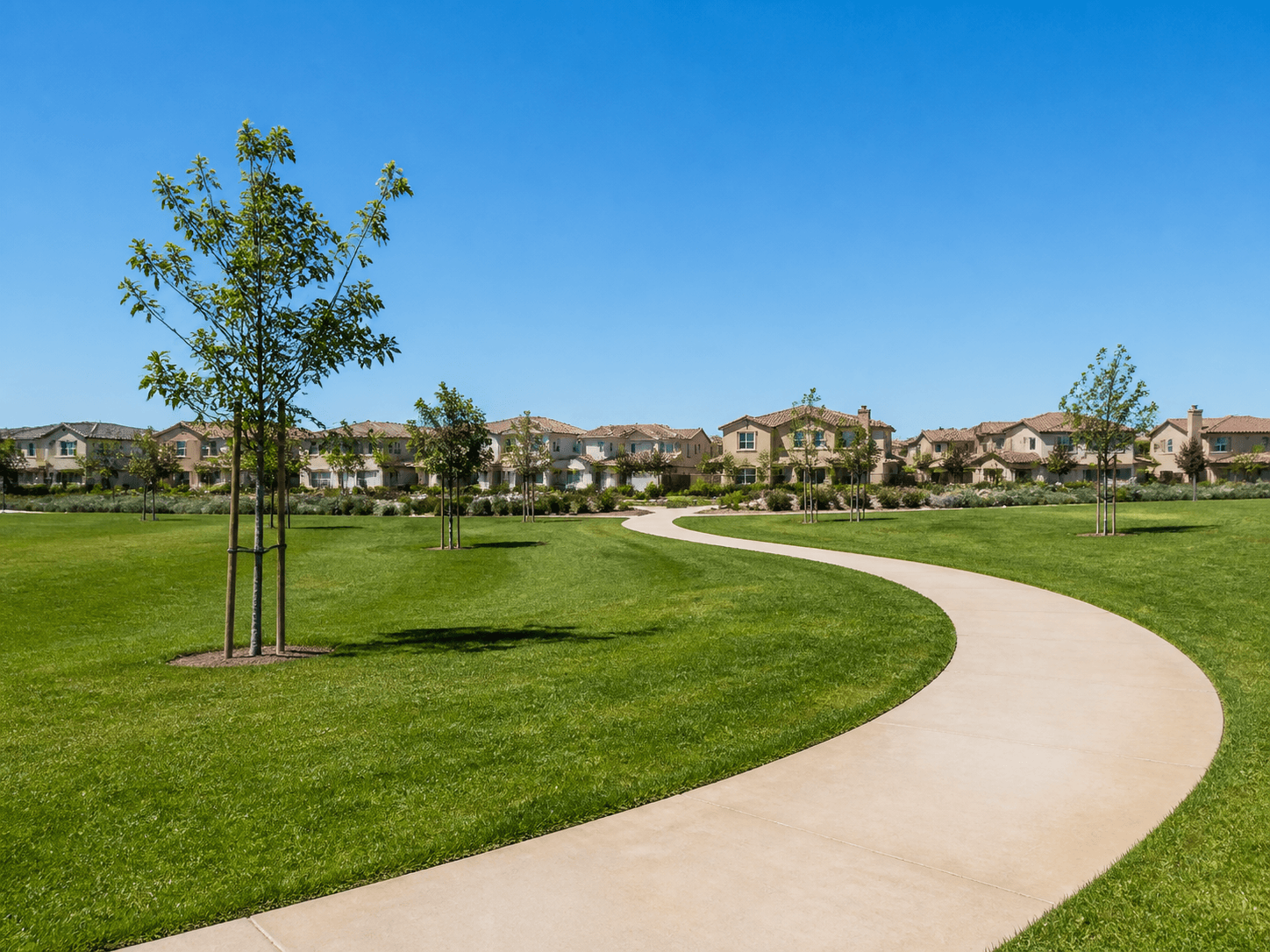 A bright neighborhood park in Cypress, CA with open green lawn and houses visible beyond