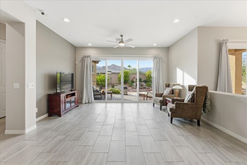 Bright open living area with sliding glass doors opening to a desert-landscaped backyard