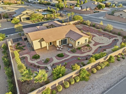 Aerial view of a single-story desert-landscaped home with a private patio and walled backyard