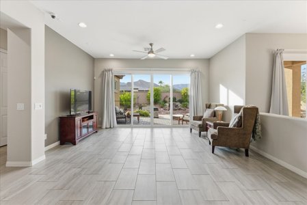 Bright open living room looking out to a landscaped backyard and mountain views in a Las Vegas valley home