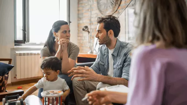 Family in a serious discussion with a real estate advisor about homeownership options during financial hardship