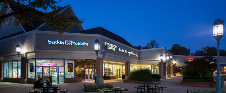 North Point Village Center storefronts lit at dusk