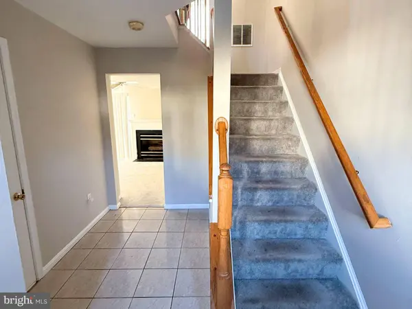 Lower-level foyer, carpeted staircase and tile flooring  