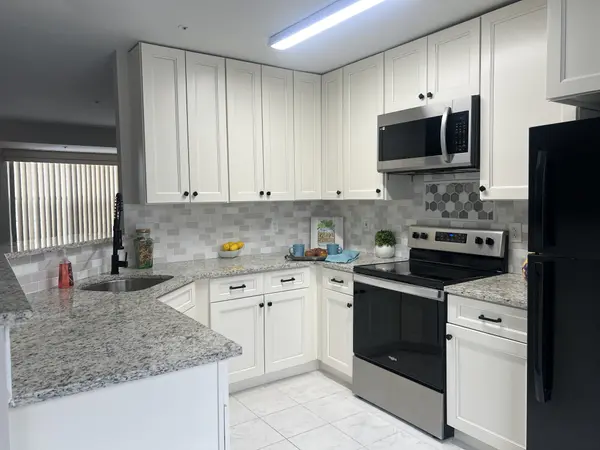 Updated kitchen, granite countertops, white cabinets, and stainless steel appliances