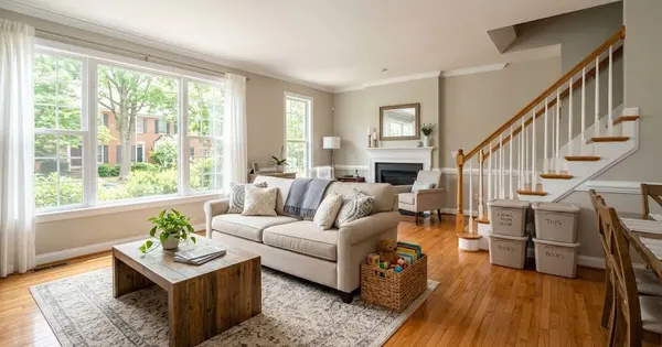 Illustration of a tidy, lived-in Northern Virginia townhome living room with labeled storage bins by the stairs, for a guide to selling an Ashburn home while living in it