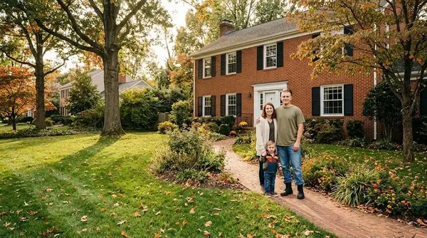 Military family standing in front of their new brick colonial home in Northern Virginia