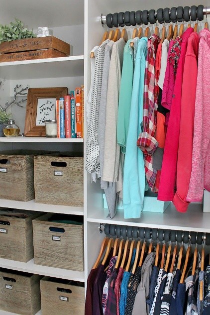 Organized closet after decluttering with neatly arranged clothing and storage bins