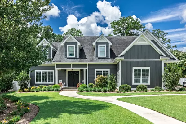 A large gray craftsman new construction house with a landscaped yard and leading pathway sidewalk (3)