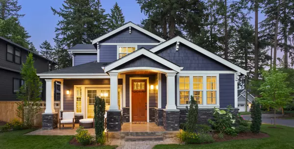 Beautiful home exterior in evening with glowing interior lights and landscaping