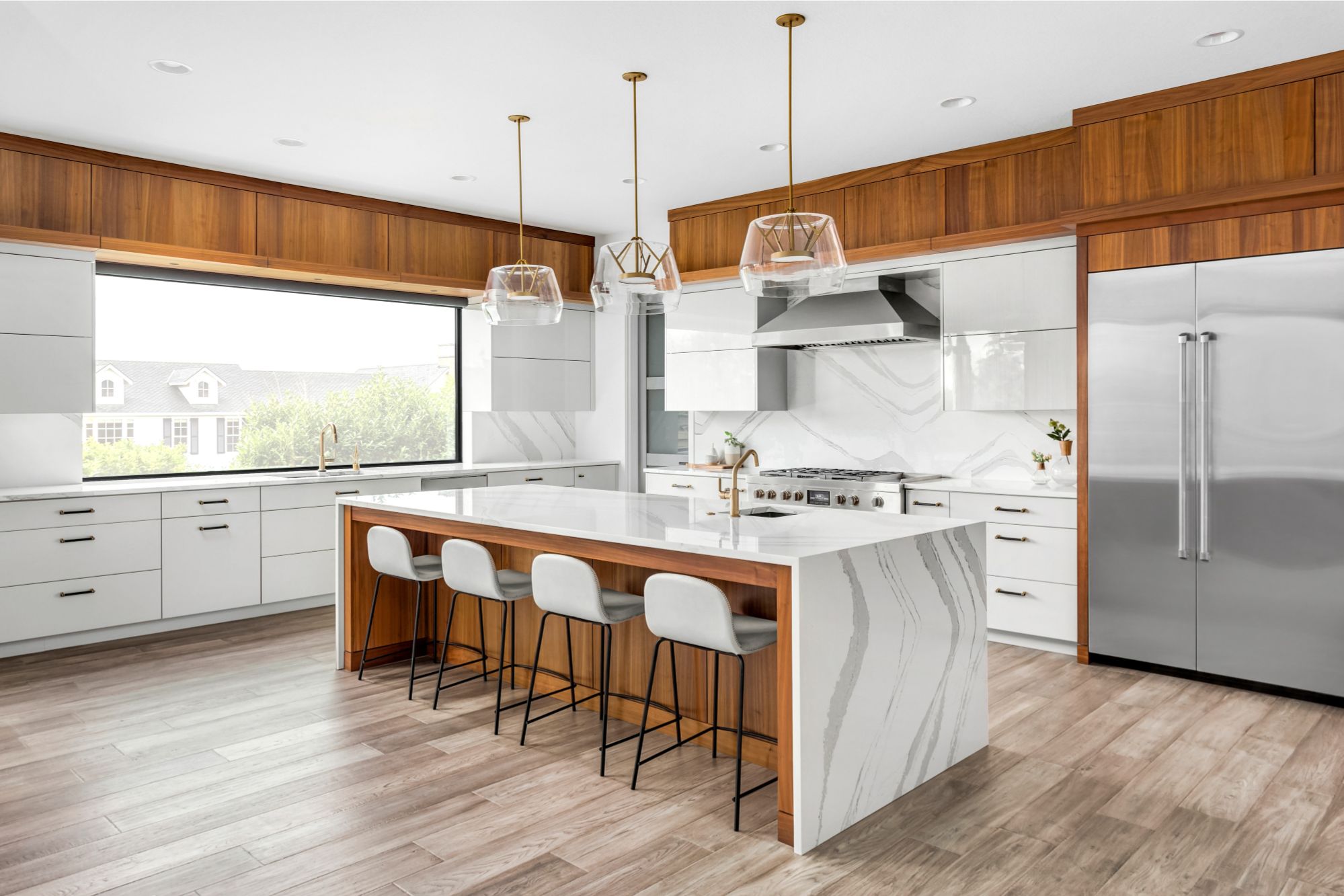 Beautiful kitchen in new luxury home with large waterfall island, gorgeous backsplash and cabinets.