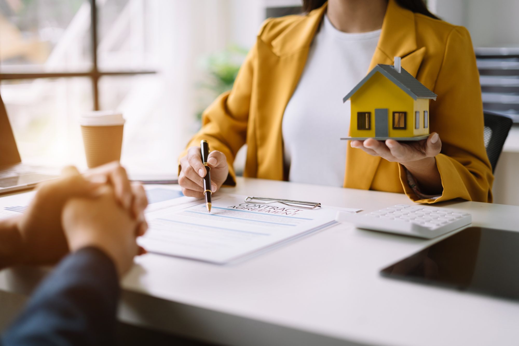 Real estate broker agent presenting and consult to customer to decision making sign insurance form agreement, home model, concerning mortgage loan offer in office