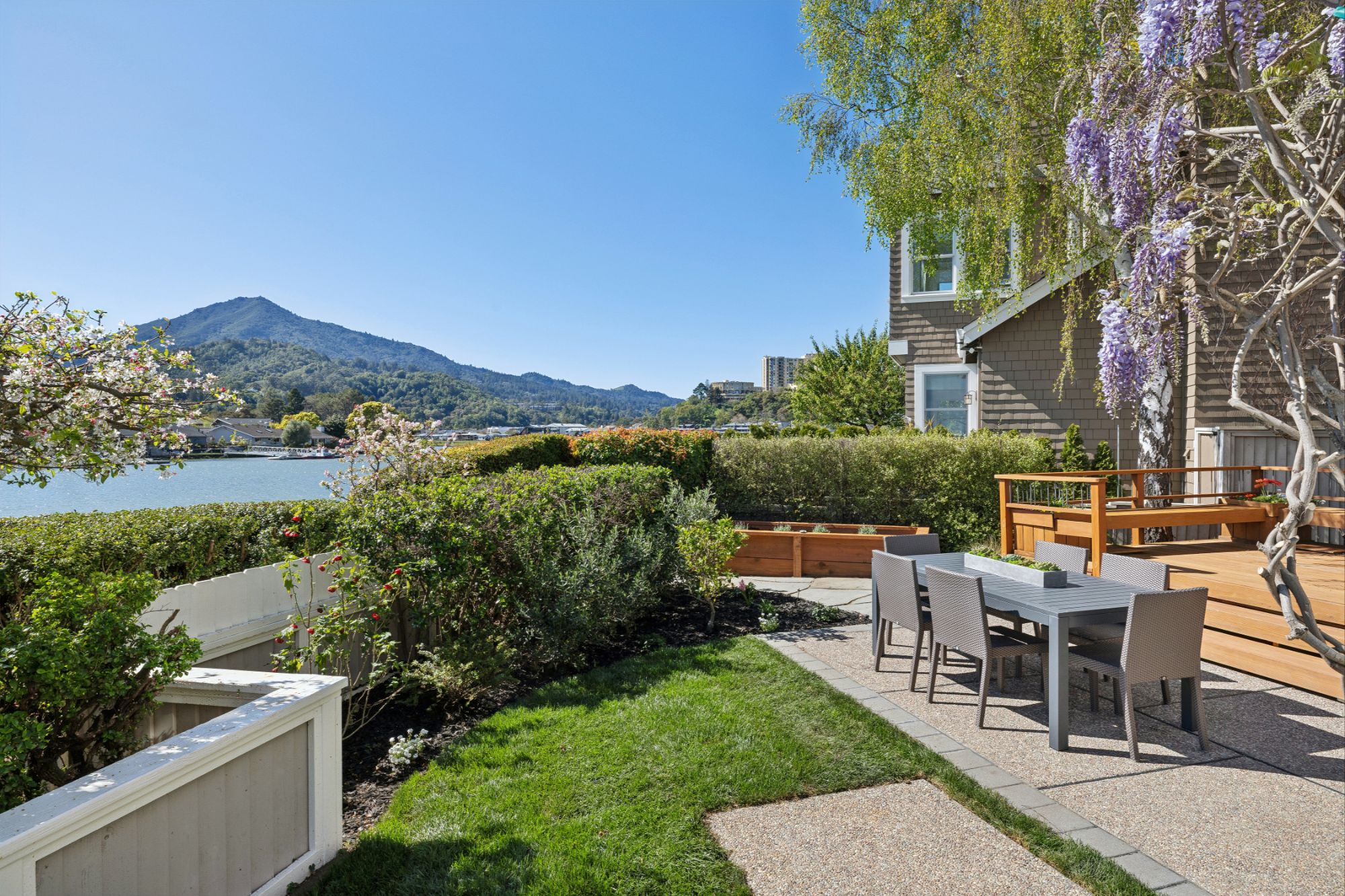 Outdoor space with a lake and a space to rest with some tables and chairs