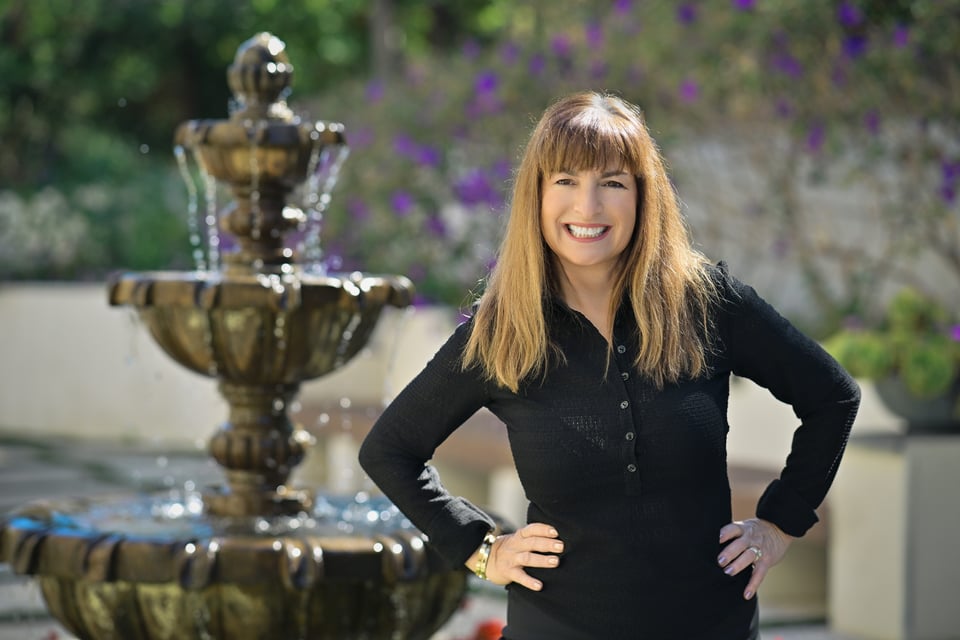 Pam Smiling to the camera near to a fountain