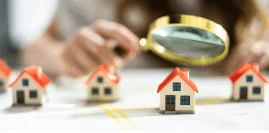 Magnifying glass over mini model homes on map
