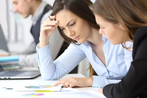 Worried businesswomen analyzing growth graphs
