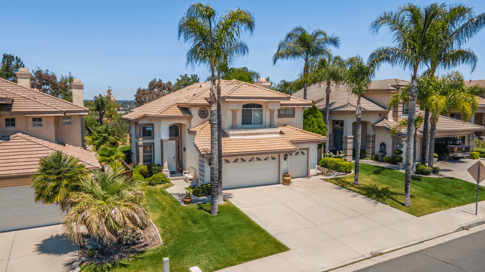 Southern California home exterior with palm trees and blue sky