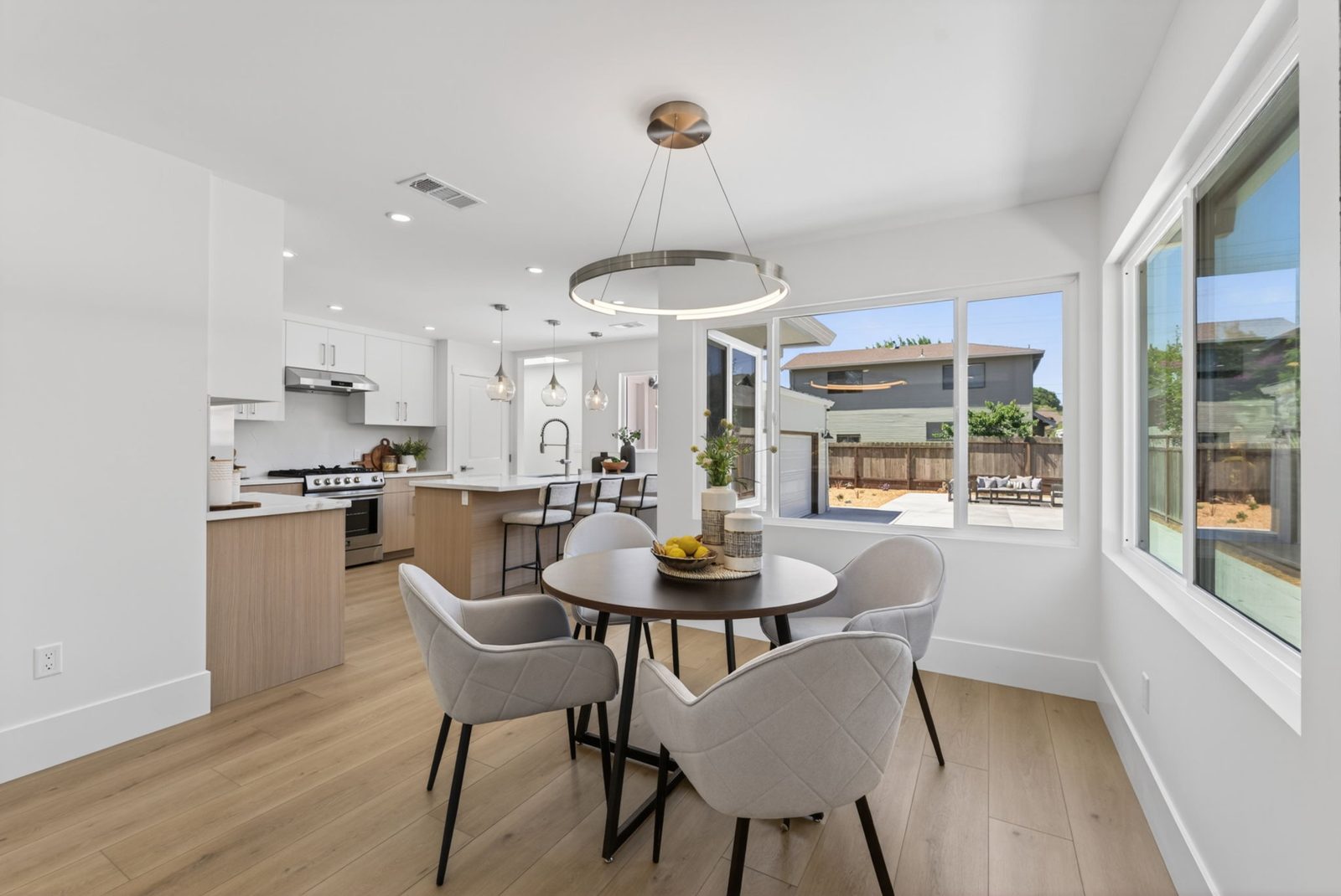 Dining area under a statement pendant, open to the kitchen.