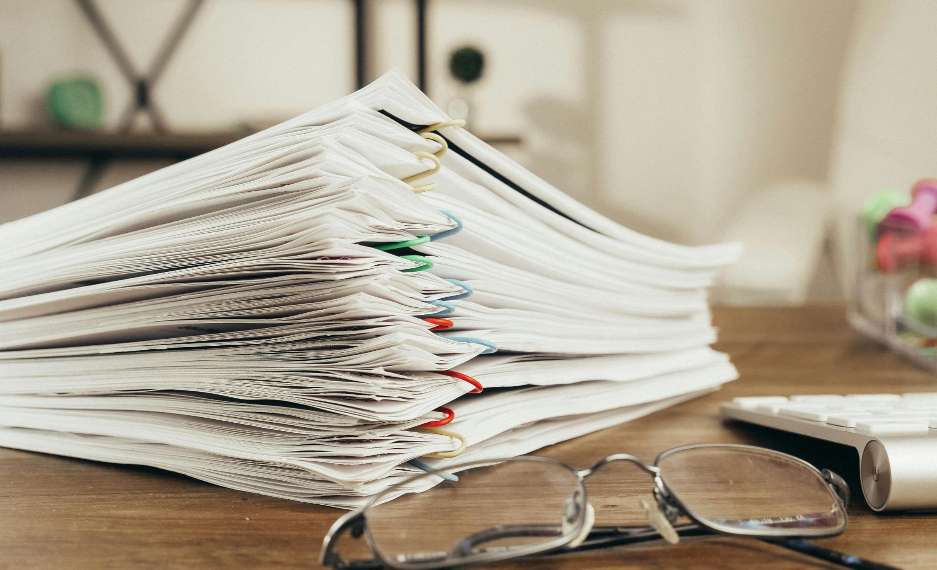 Organized paperwork and eyeglasses on a desk reflect the serious decisions Boulder homeowners face when considering divorce and real estate choices