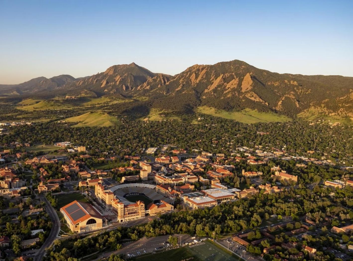 Aerial view of University of Colorado Boulder's Norlin Quadrangle with the Flatirons and Rocky Mountains in the background