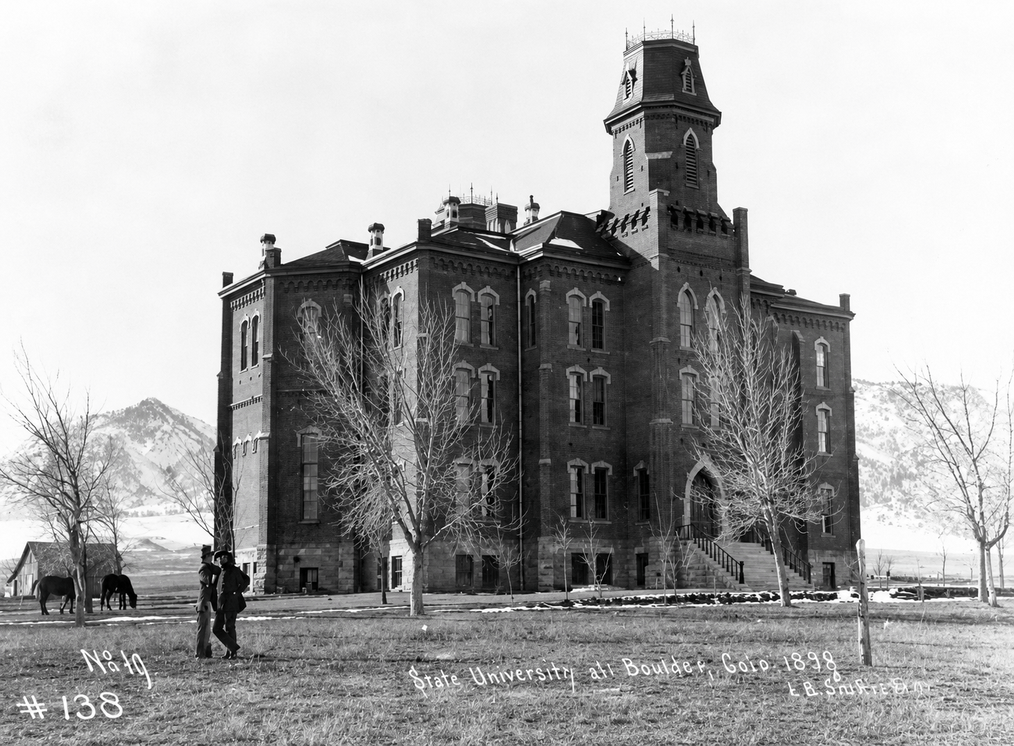 Old Main building at the University of Colorado Boulder with the Flatirons rock formations in the background, completed in 1876