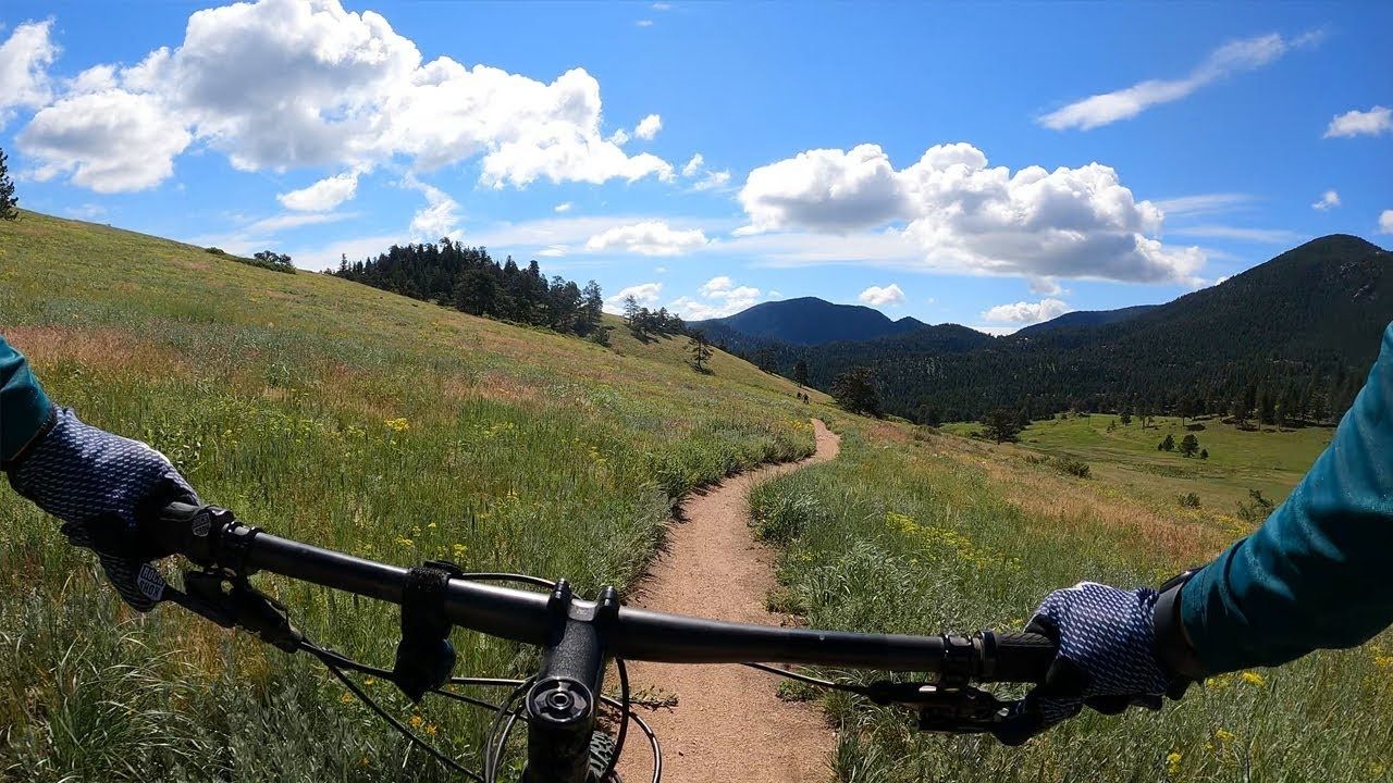 Cyclist on a Boulder, Colorado bike path with mountains in the background