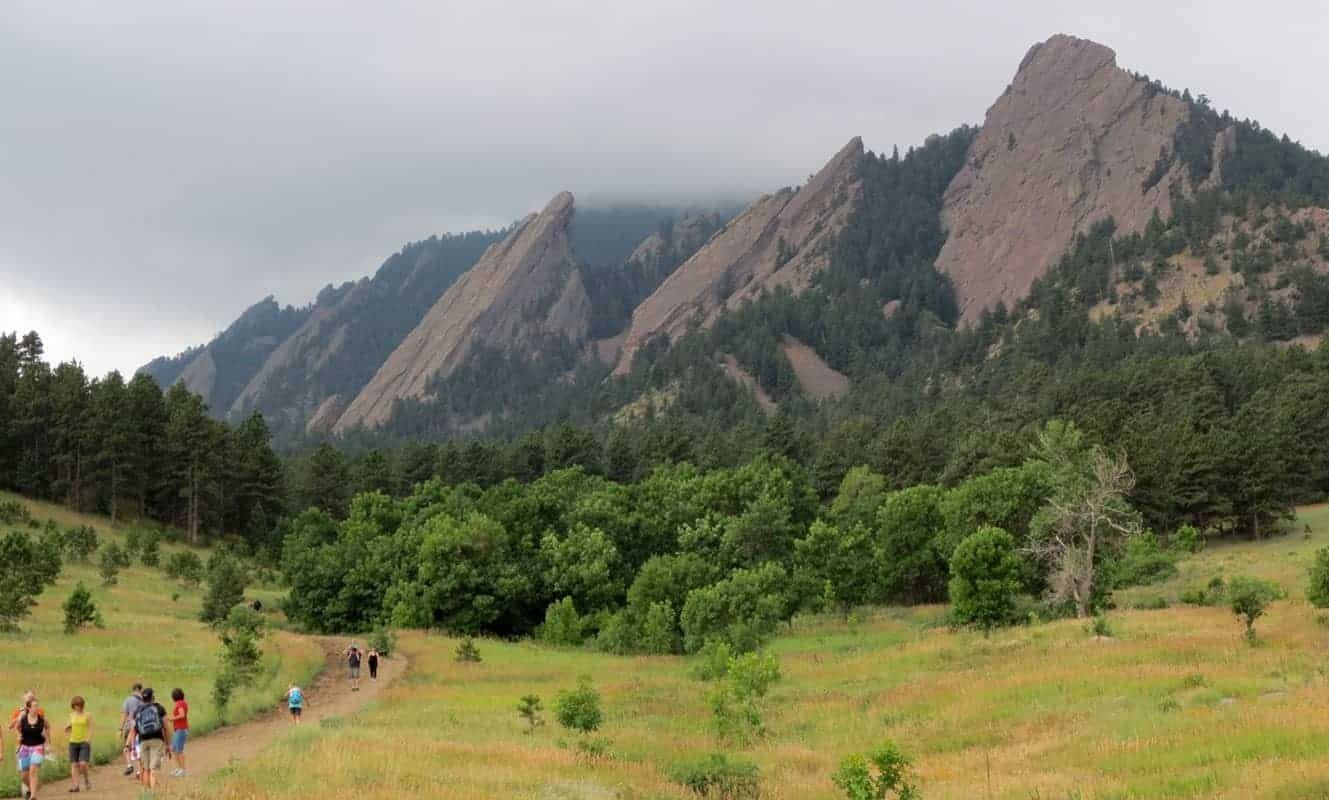 Visitors walking through Chautauqua Meadow beneath the Flatirons in Boulder.