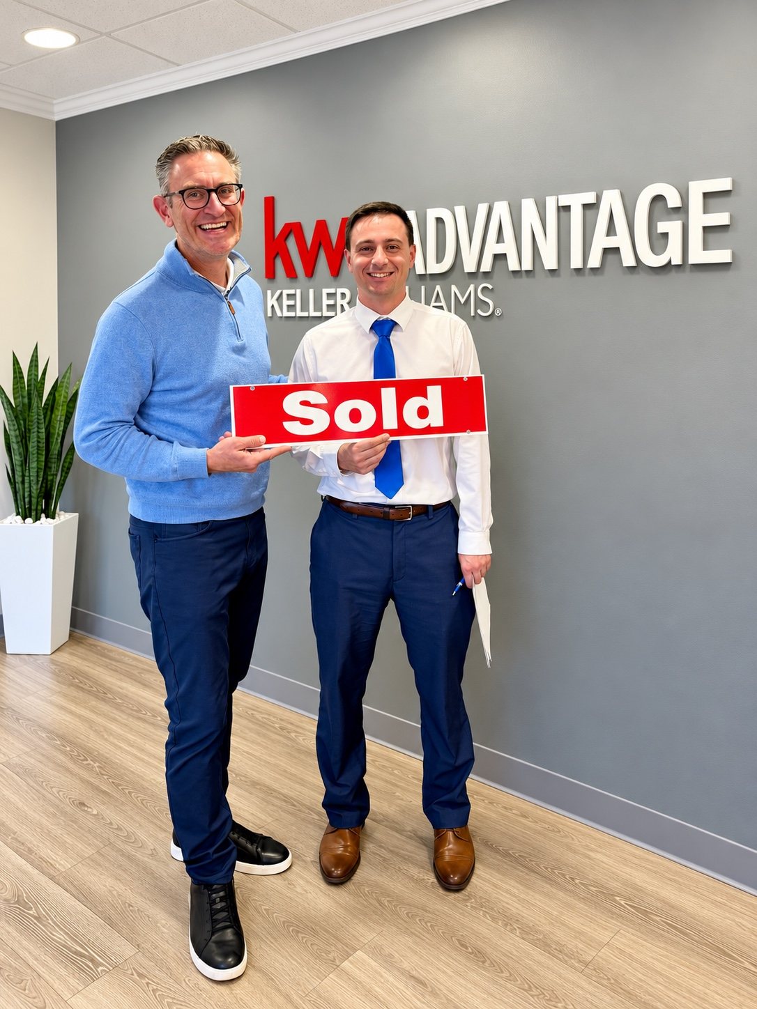 Jeff Duneske and first-time homeowner Daniel celebrating his Farmington Hills home closing with a Sold sign