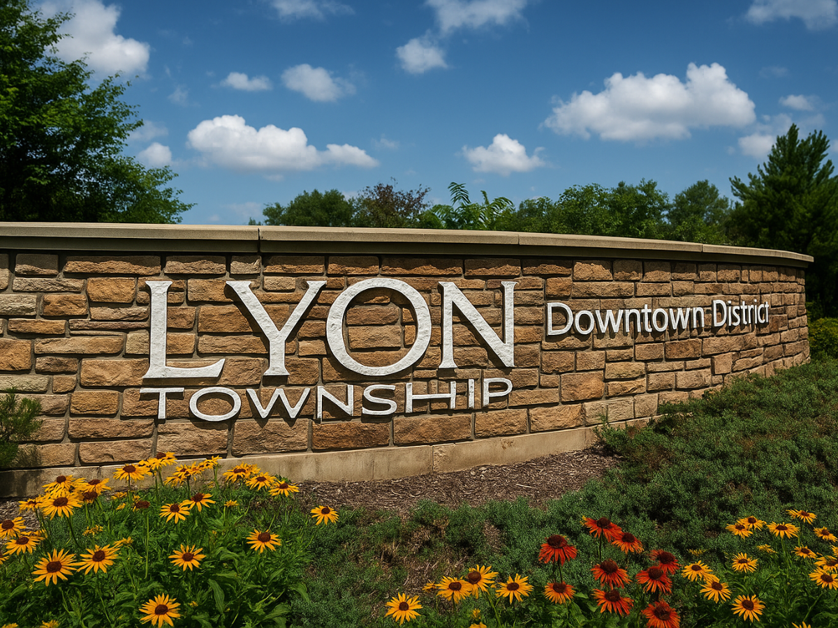 Lyon Township Downtown District entrance sign surrounded by flowers and landscaping.