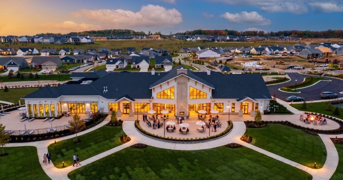 Aerial evening view of The Lake House clubhouse and the surrounding homes at Kensington Ridge in Milford, Michigan