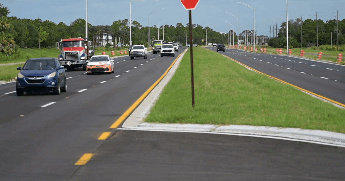 Newly widened River Road in South Sarasota County with multiple lanes of traffic, a grassy median and new street lighting