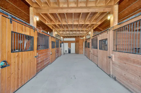 Barn interior with 6-stalls and stairs to loft above the aisle