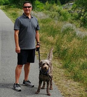 Jeffrey walking along the river walk in Oliver with his dog Cooper