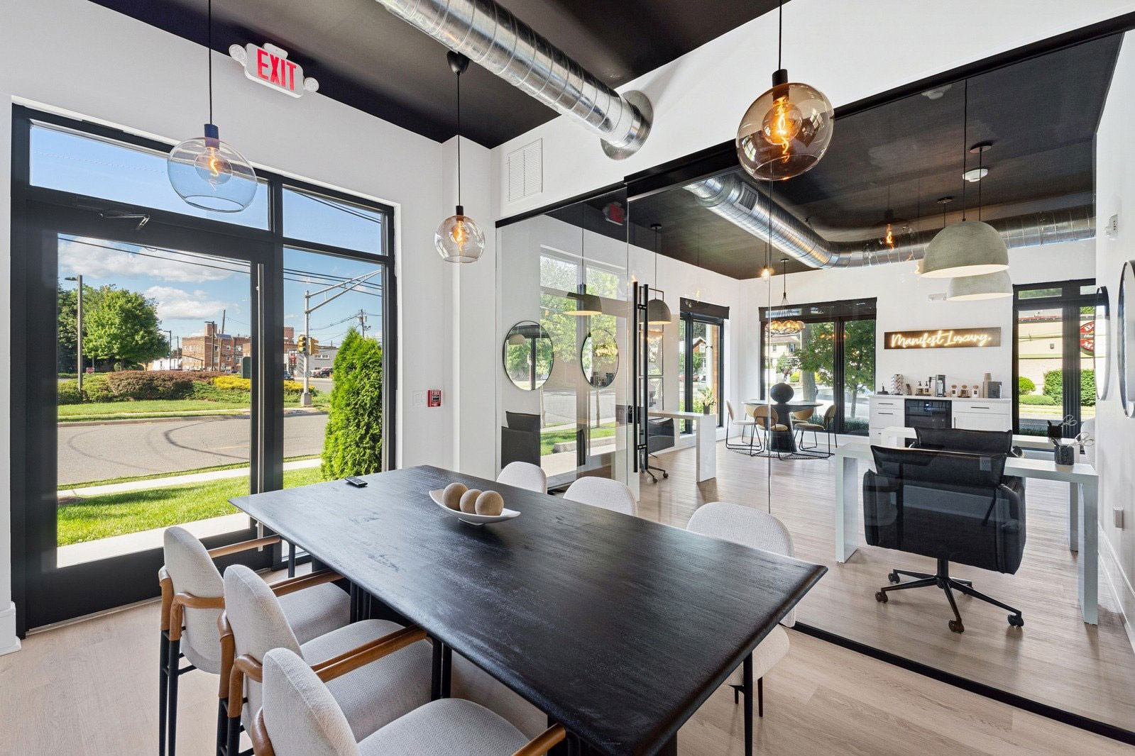 Bright meeting room with large table, metal ductwork and pendant lights, landscape aspect ratio 720:420