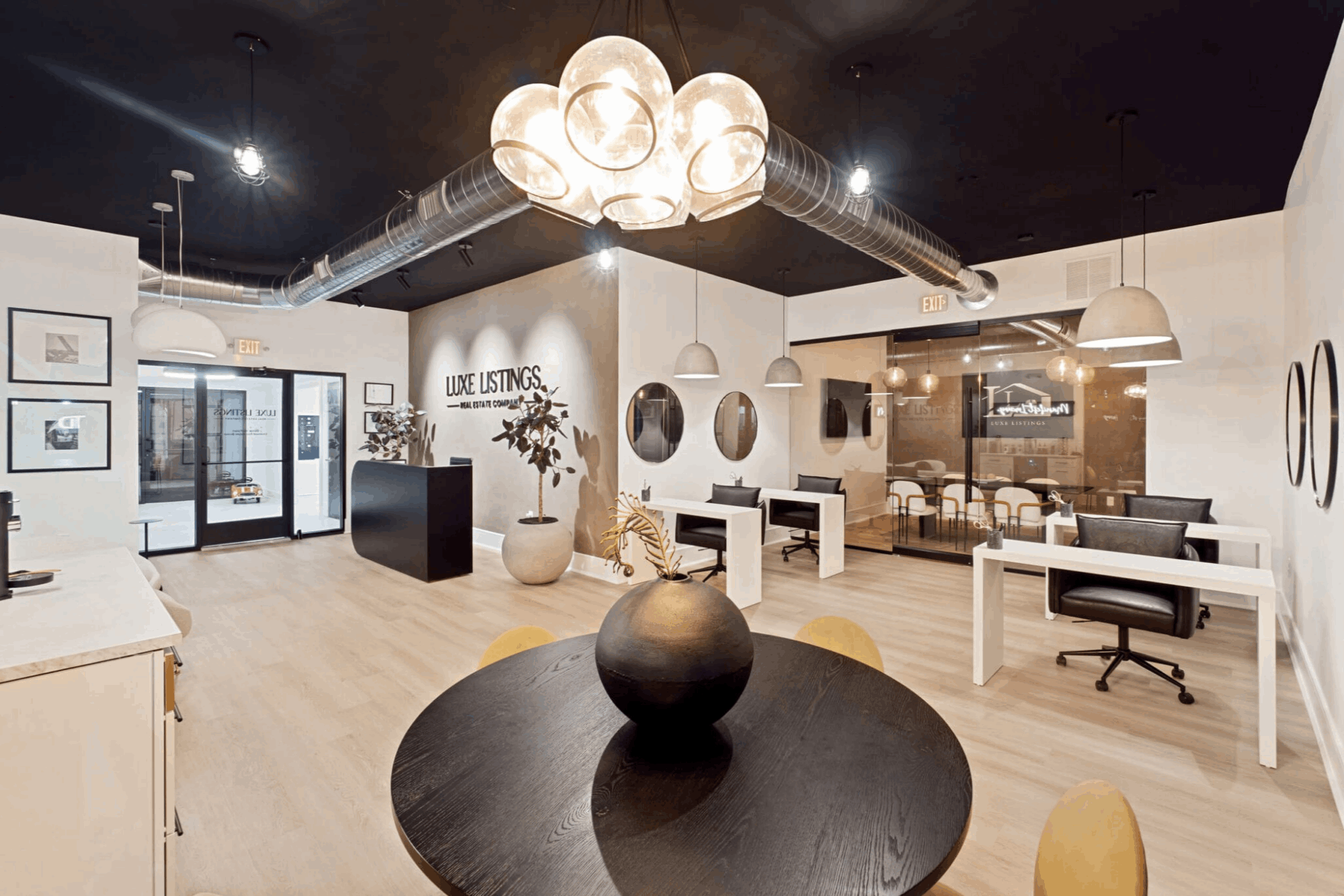 Contemporary office lounge with round table and pendant lighting, open layout and warm wood floors, landscape aspect ratio 720:420