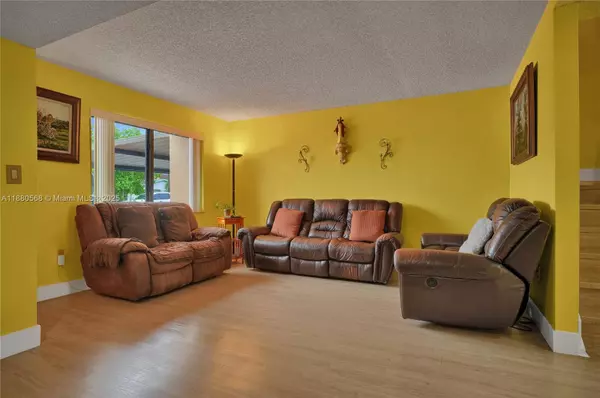 Living room in Sweetwater Miami townhouse at 11217 SW 1st St #5 featuring PVC floors, large window with impact glass, and comfortable open layout.