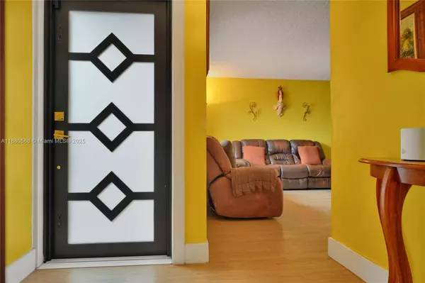 Interior view of Sweetwater townhouse entrance with modern impact door, pvc flooring, and access to living room.