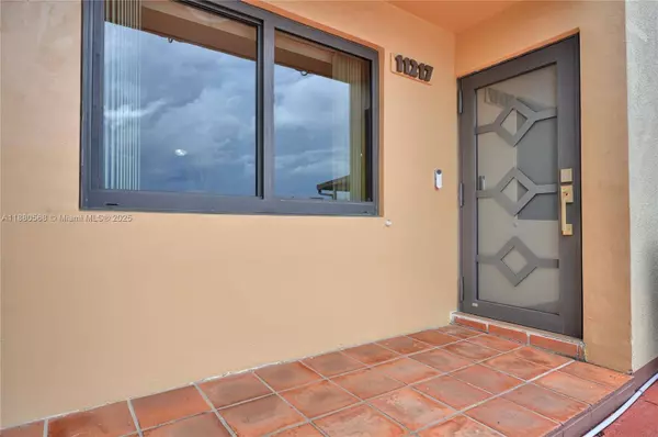 Front entrance of Sweetwater Miami townhouse at 11217 SW 1st St #5 featuring impact-resistant door, impact windows, and tiled entryway.