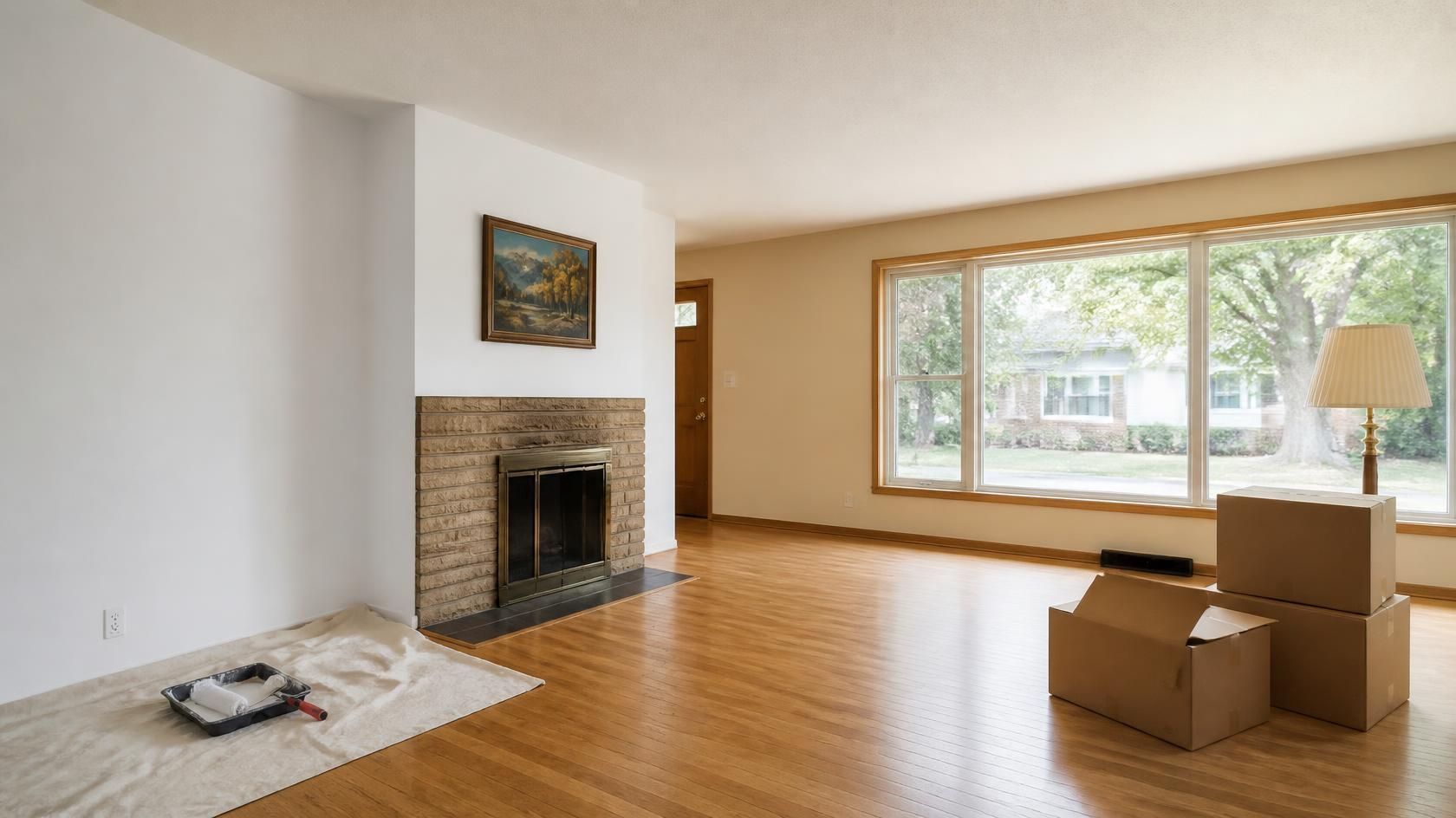 Cleared-out living room in an inherited Denver home with moving boxes and painting supplies, ready to prepare for listing.