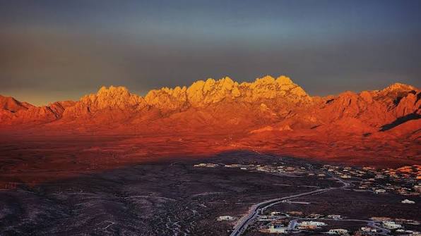 Organ Mountains glowing at sunset above a Las Cruces neighborhood