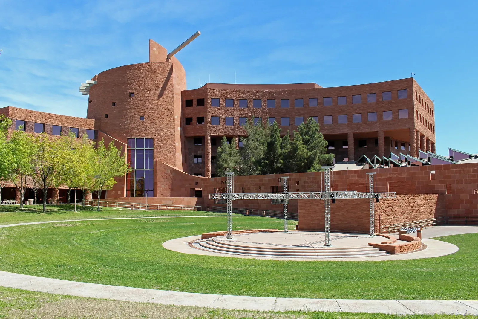 Red brick Clark County Government Center with circular tower and green lawn under blue sky