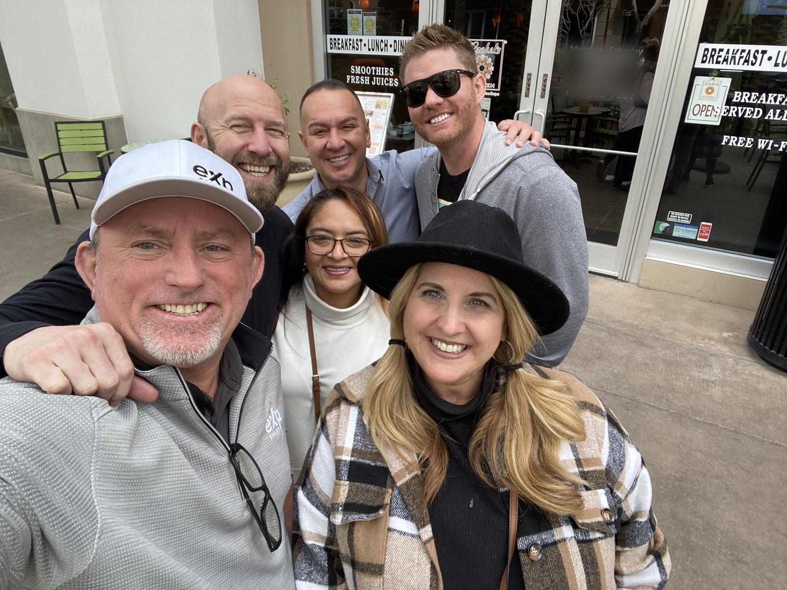 Nate Smith and five eXp Realty teammates smiling outside a cafe