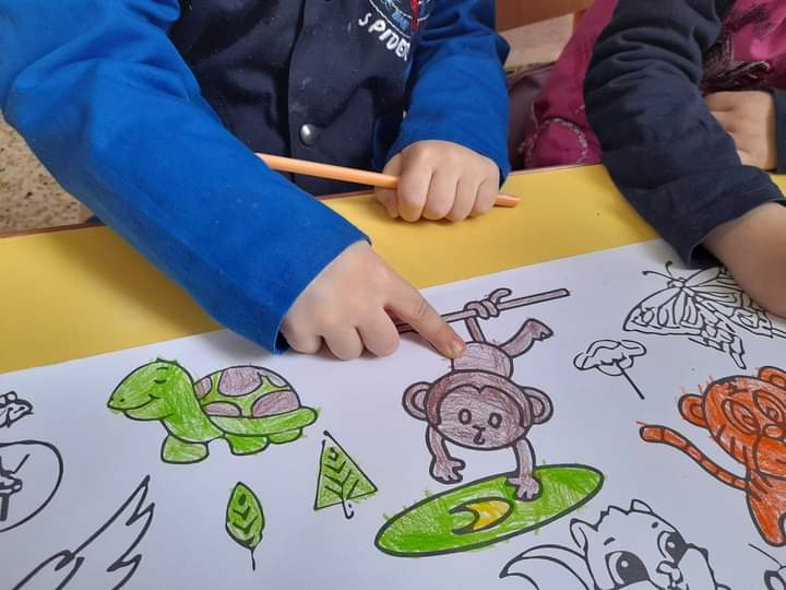 Child’s hands coloring with crayons, representing school choice and learning in Charleston