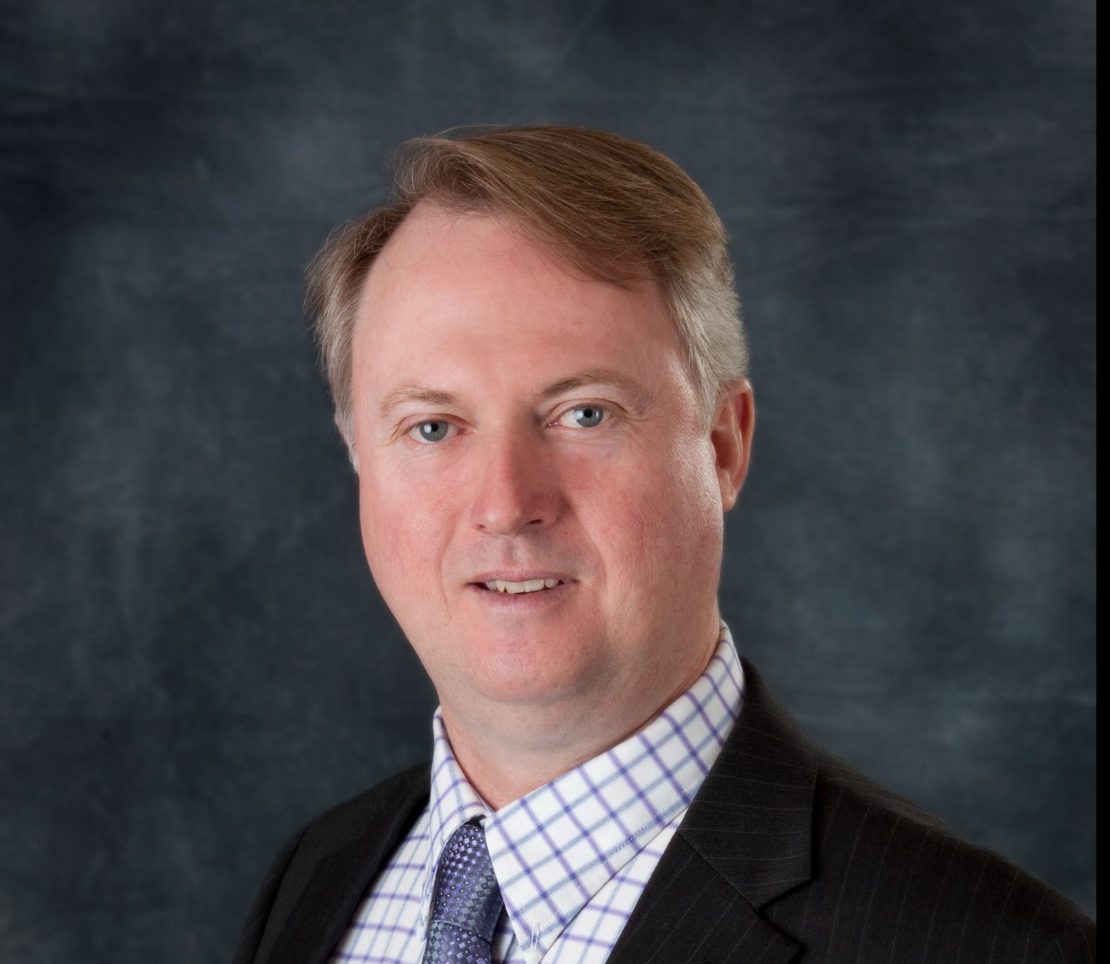 Terry Thompson Portrait photo wearing a dark suit and tie