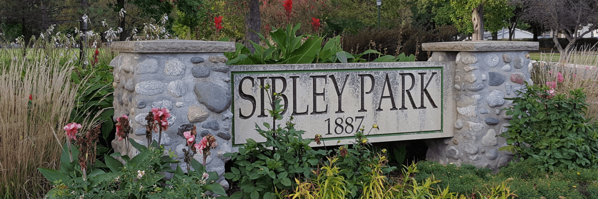 Sibley Park stone entrance sign surrounded by flowers in Mankato, Minnesota
