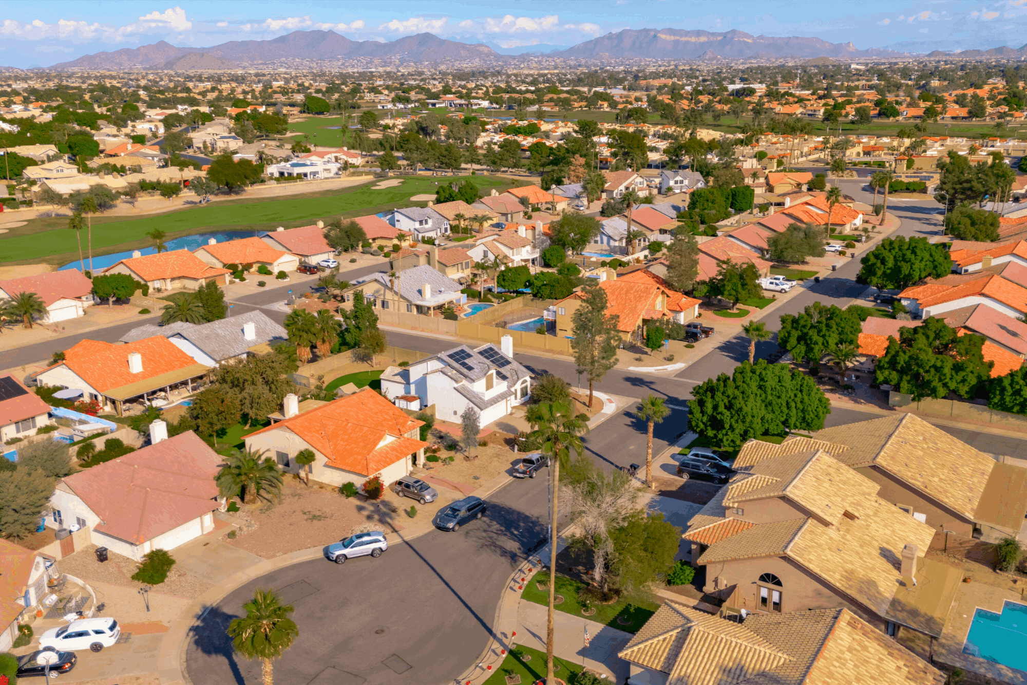 Aerial view of a residential neighborhood in Mesa, Arizona near the 85205 zip code, featuring single-family homes with pools, mature landscaping, and mountain views&mdash;an area known for strong real estate demand and short-term rental potential.