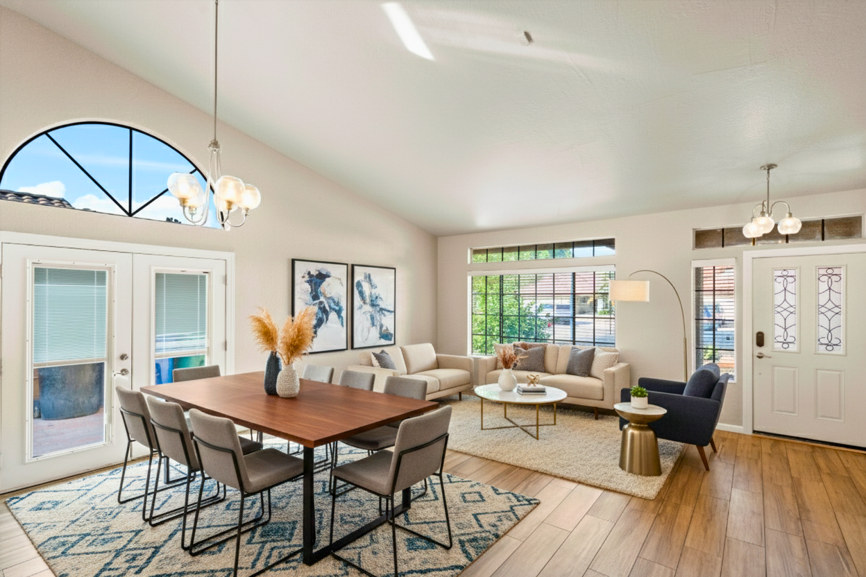 Open dining and living area in a Mesa Arizona home with vaulted ceilings, large windows, and natural light, featuring an open-concept layout ideal for entertaining or short-term rental use.