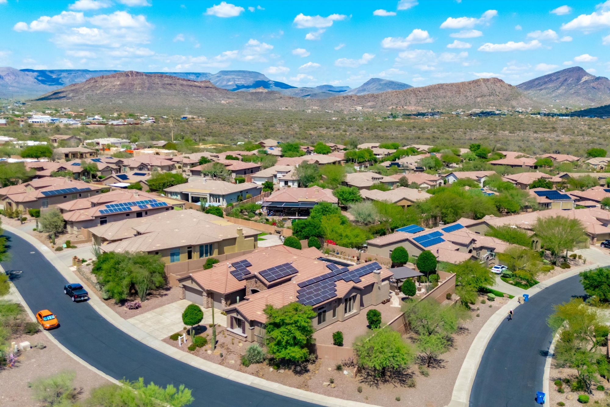Aerial view of a Phoenix Arizona residential neighborhood featuring single-family homes with desert landscaping and mountain views, illustrating housing options, timing considerations, and market conditions for homeowners selling or holding property in the Phoenix real estate market heading into 2026.